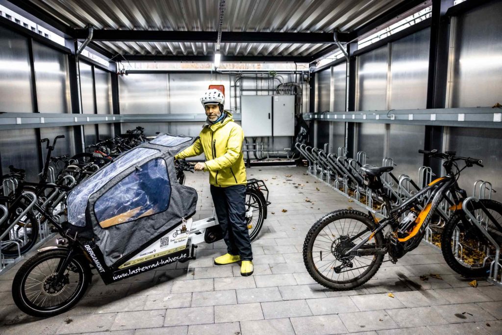 Mann mit Lastenrad in der großen Fahrradgarage von Schwalbe